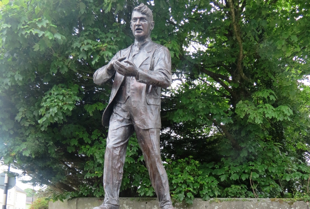 Michael Collins statue a Clonakilty, nella contea di Cork, circondato da alberi.