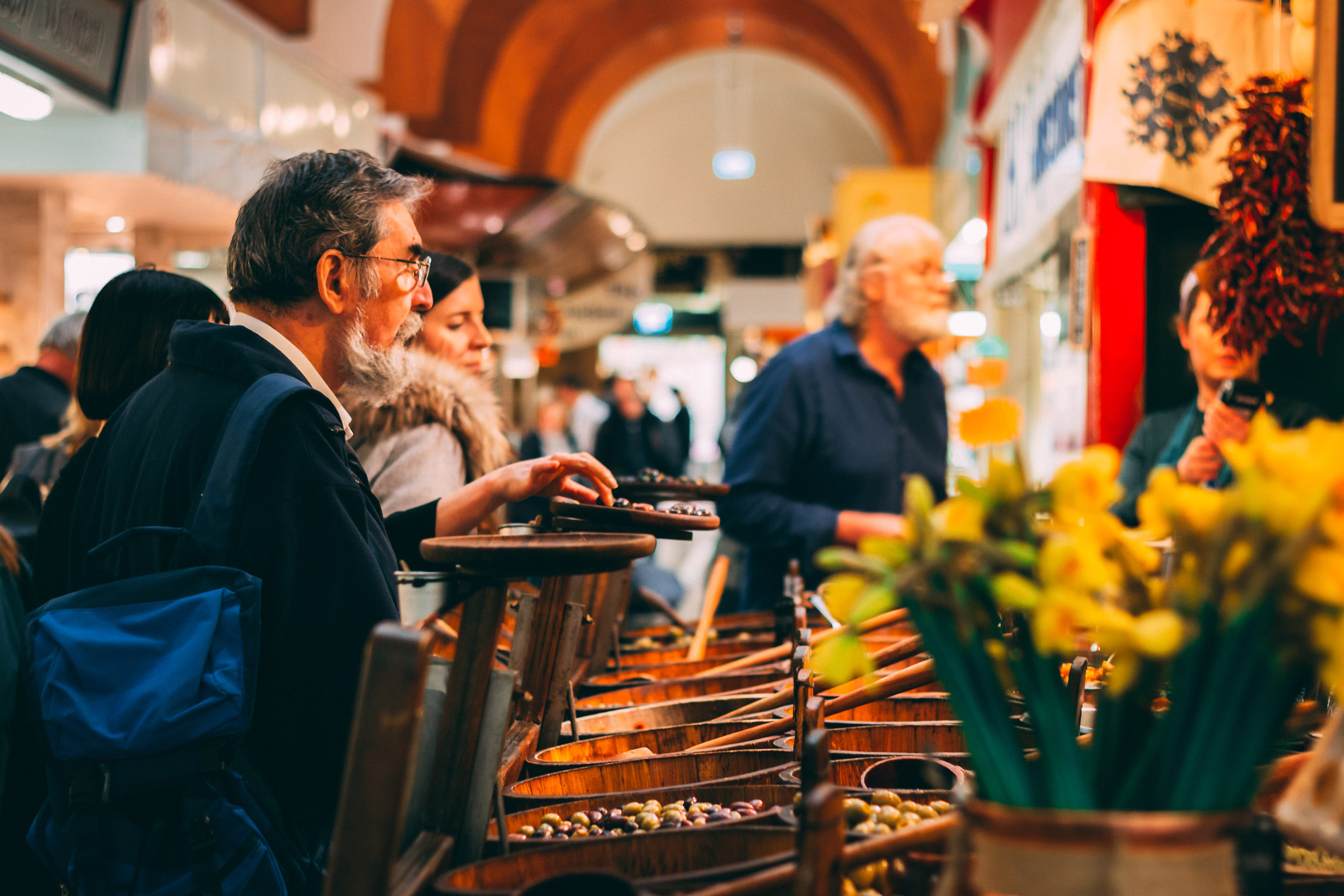 Shoppers die kraampjes bekijken op een drukke Ierse boerenmarkt.