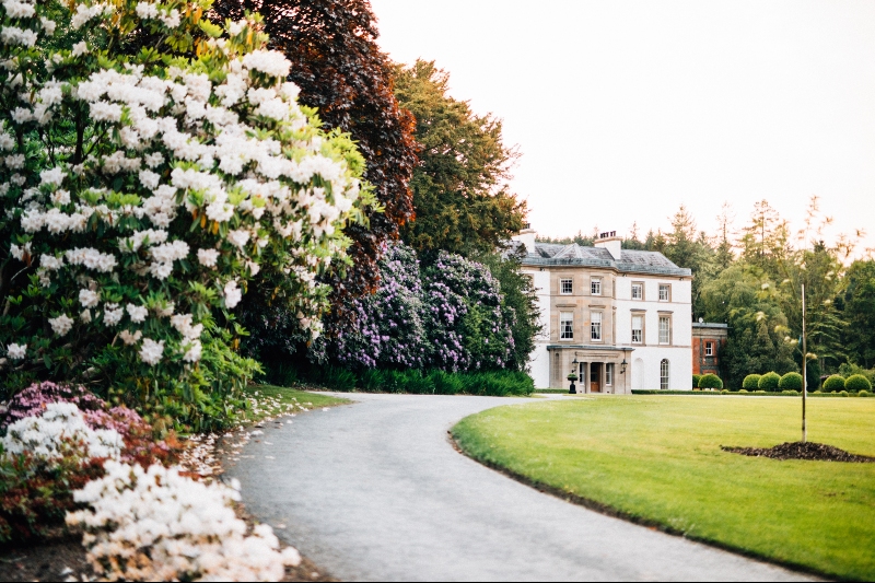 Montalto House in County Down, a grand estate framed by blossoming gardens and tree-lined paths in full bloom.