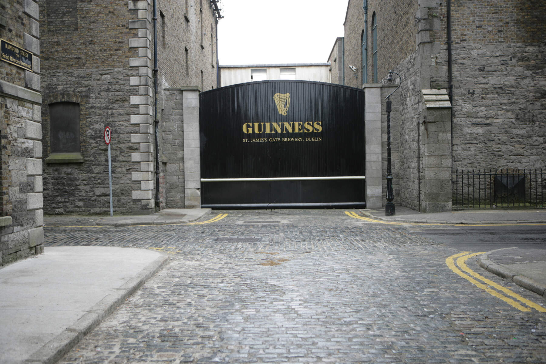 Zwarte poorten met het gouden Guinness-logo bij de St James's Gate Brewery in Dublin, Ierland.