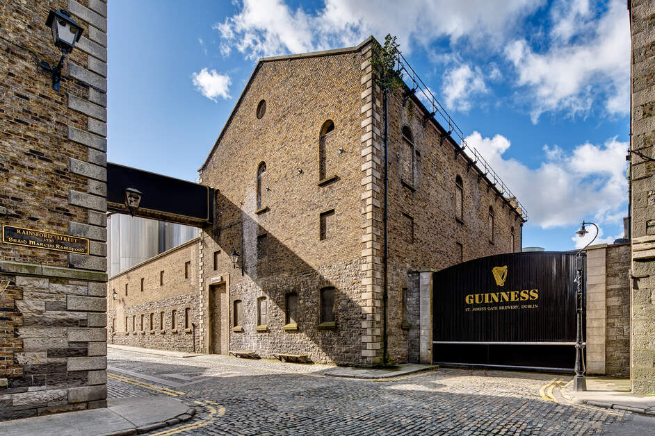 Black Guinness gate and old brick brewery buildings on Rainsford Street, St James’s Gate Brewery in Dublin.