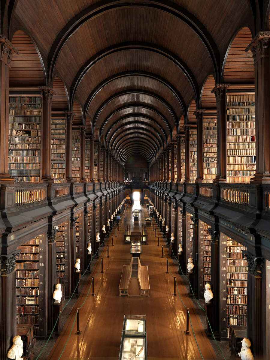 Het interieur van de Long Room-bibliotheek aan het Trinity College Dublin, bekleed met historische boeken en marmeren bustes.