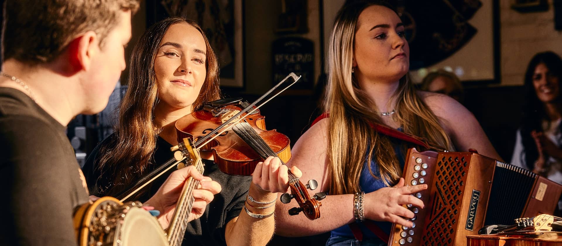 Traditional Irish music session at Kelly’s Cellars in Belfast with musicians playing fiddle, banjo and concertina.