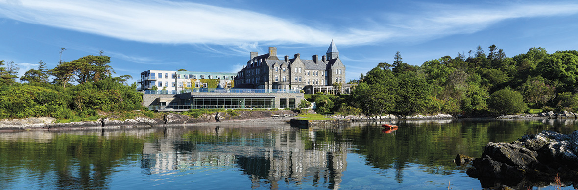 Das Parknasilla Resort mit Blick auf eine ruhige Bucht, mit Steintürmen und Glasanbau, eingebettet in den Wald in der Grafschaft Kerry.