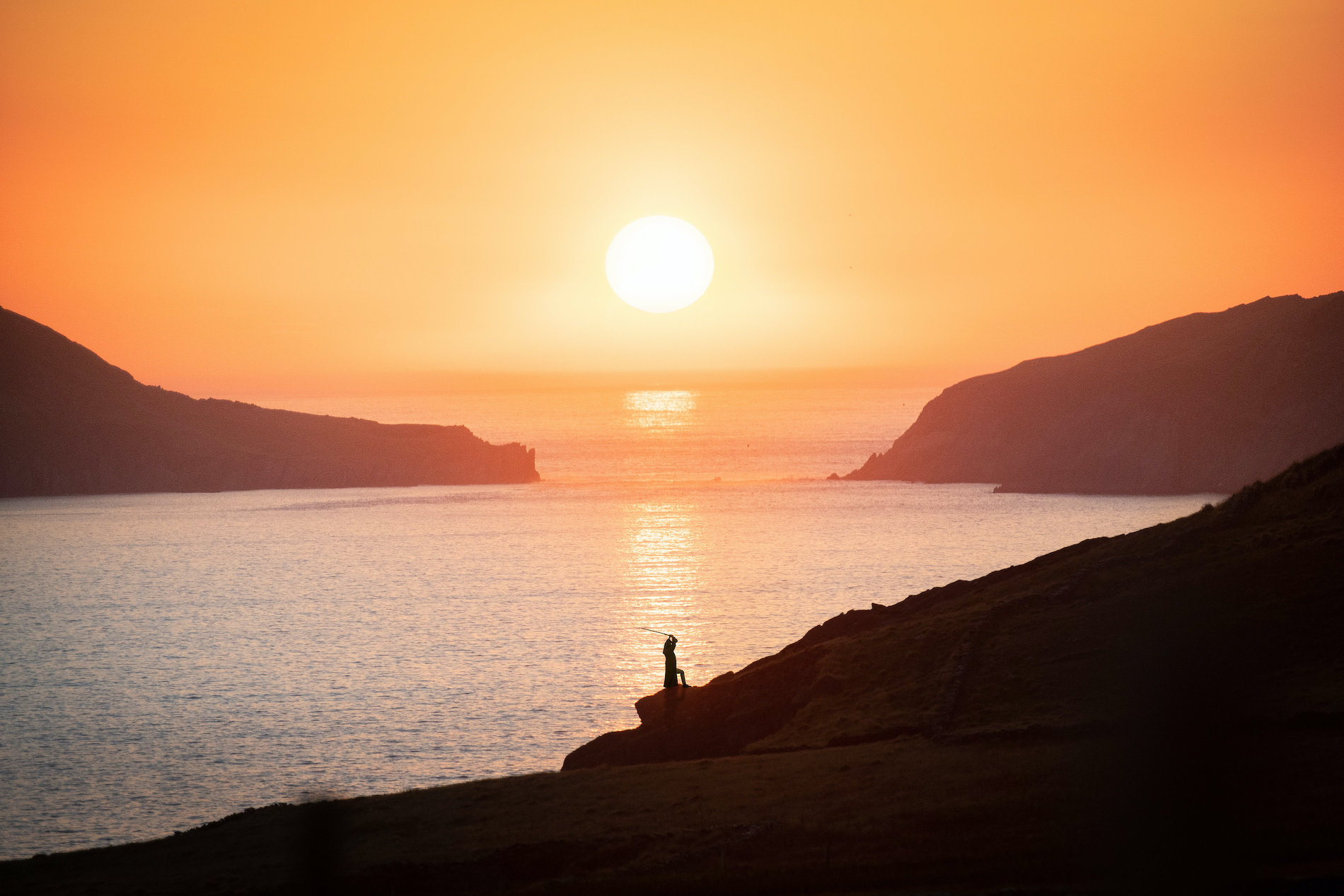 View of a sheep grazing with Skellig Michael rising from the Atlantic in the distance, on the Skellig Ring scenic route.