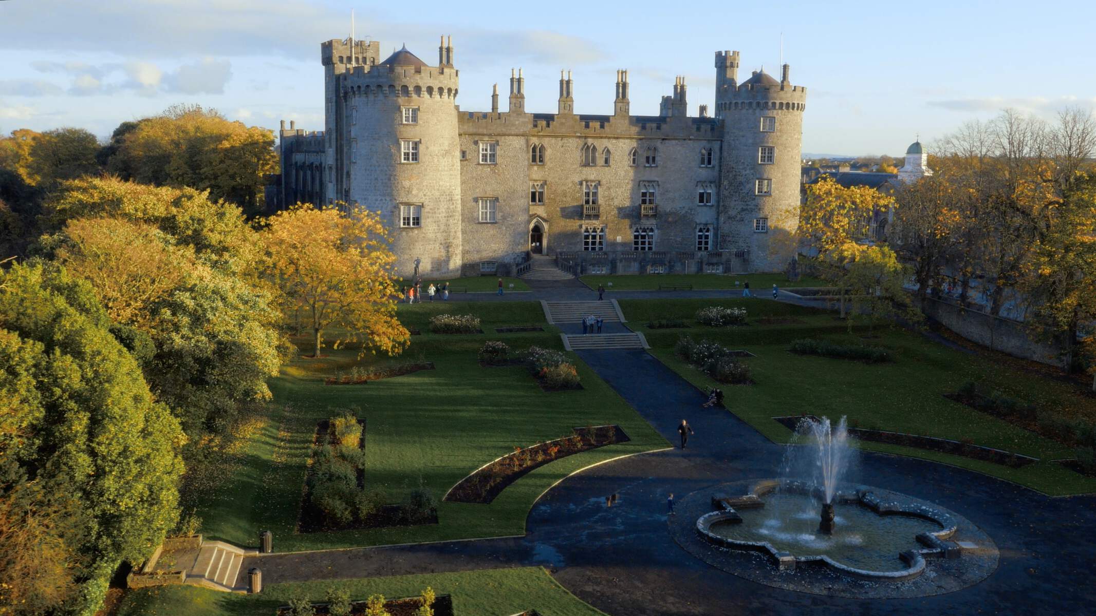 Château de Kilkenny avec jardins et fontaine devant, entouré d'arbres d'automne, comté de Kilkenny.