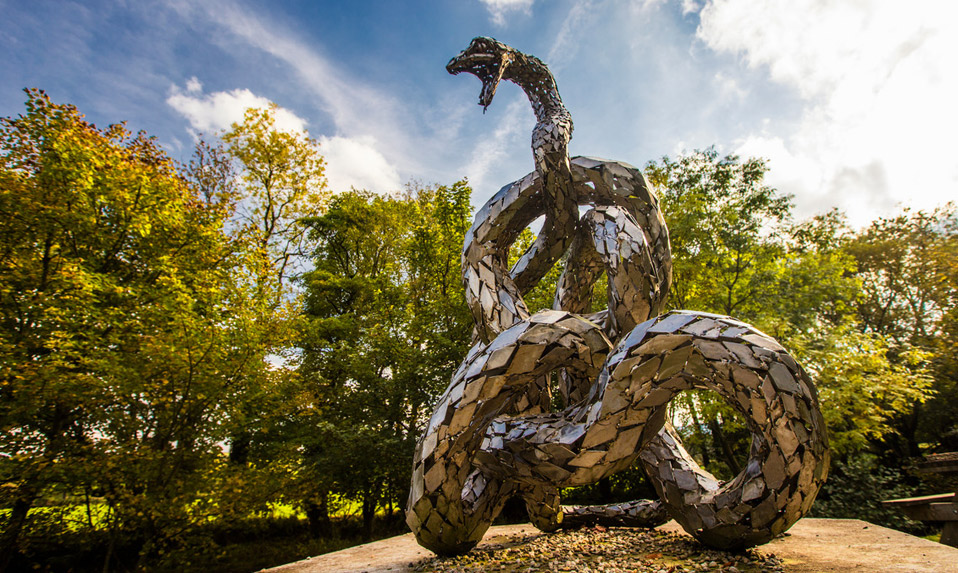 Sculpture d'un serpent en métal représentant la mythologie celte dans un cadre forestier, en Irlande.