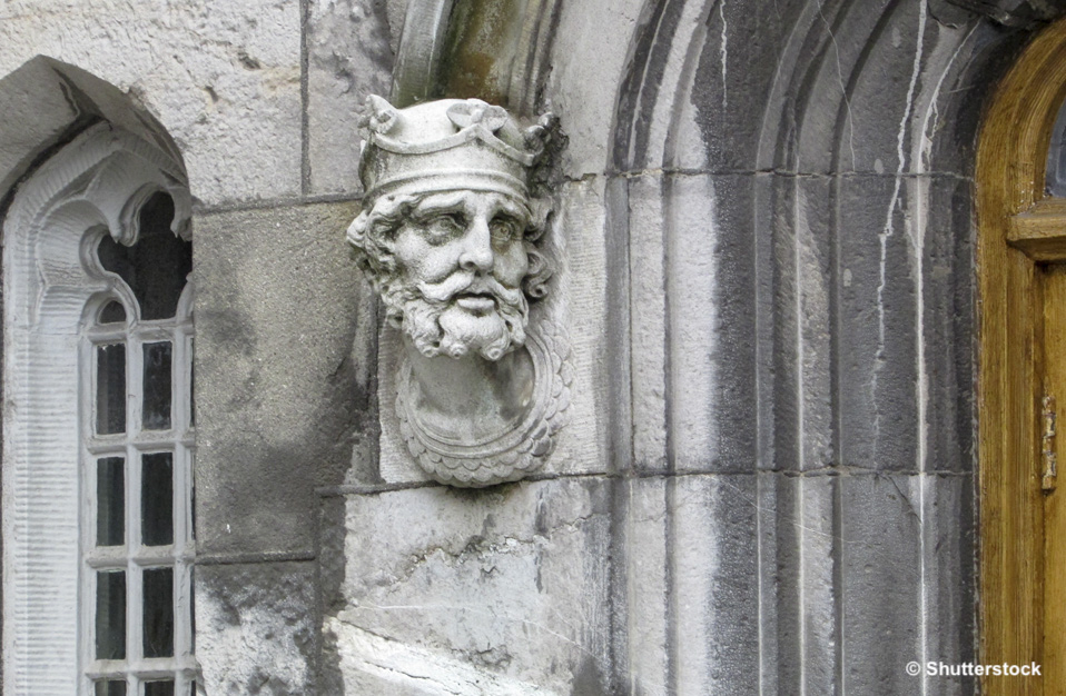 Stone head sculpture of a crowned king on a medieval building wall in Ireland.