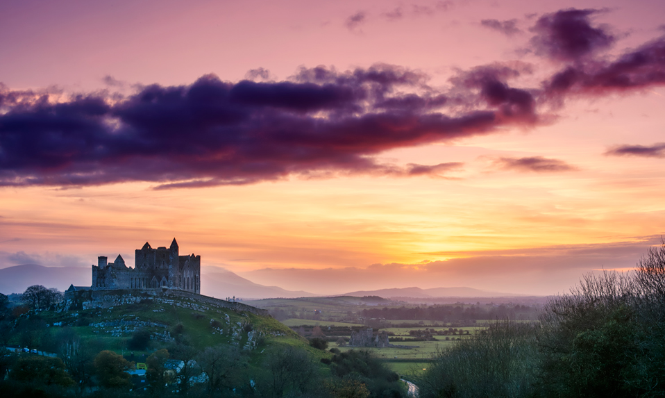 Le rocher de Cashel dans le comté de Tipperary, en Irlande, en silhouette au coucher du soleil avec un ciel dramatique.
