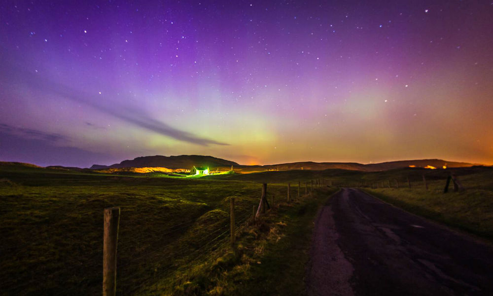 Luftaufnahme einer gewundenen Gezeitenbucht und eines goldenen Strandes mit grünen Hügeln im Hintergrund auf der Halbinsel Inishowen in Donegal.