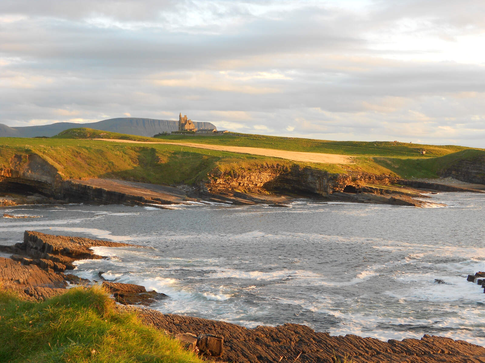 Vue sur le château de Classiebawn sur Mullaghmore Head au-dessus de la côte accidentée de Sligo et de la mer scintillante.