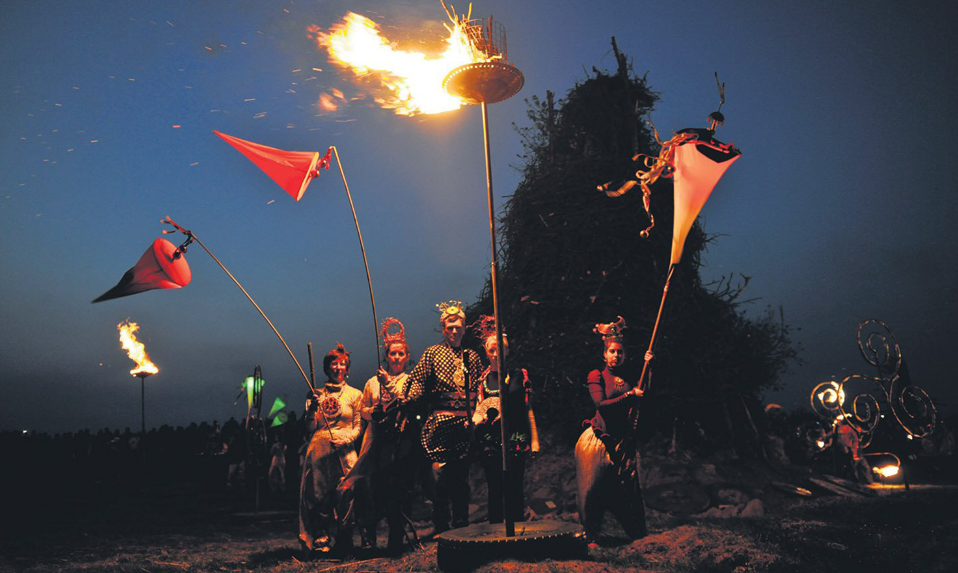 Artistes costumés avec des torches enflammées et des drapeaux lors du festival Púca, dans le comté de Meath.