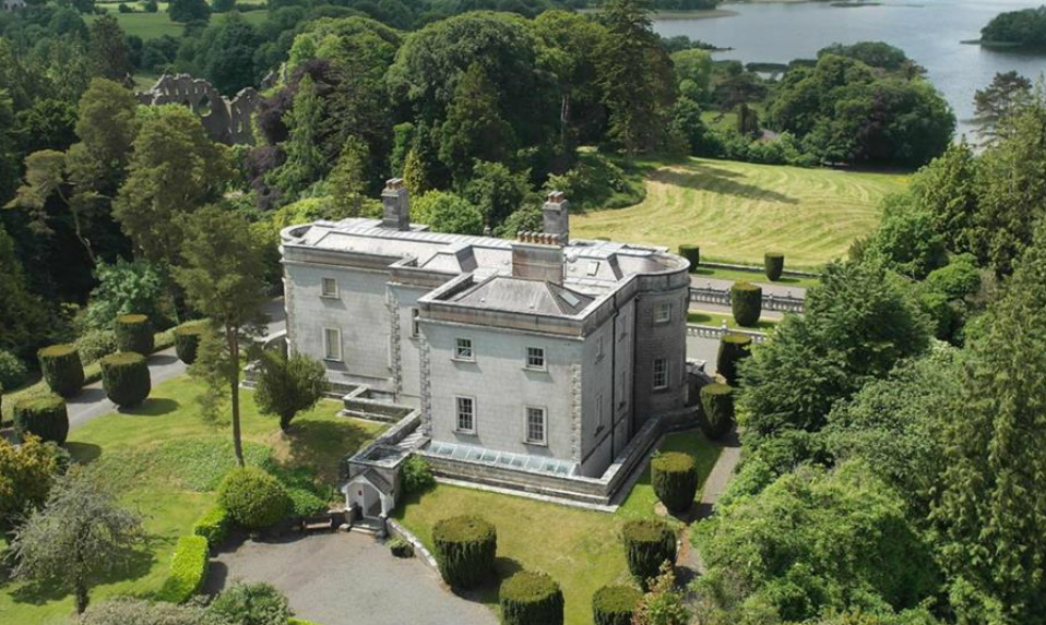 Aerial view of Belvedere House with stone exterior, manicured lawns and surrounding woodland in County Westmeath.