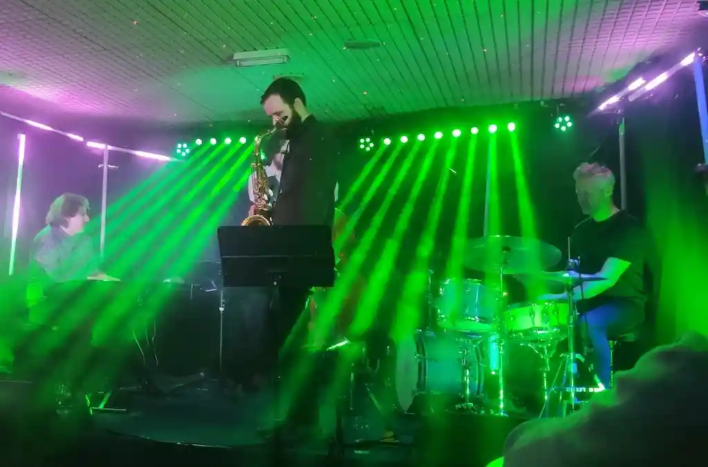 Eine Live-Jazzband spielt unter grünen Bühnenlichtern im Scott's Jazz Club in Belfast.