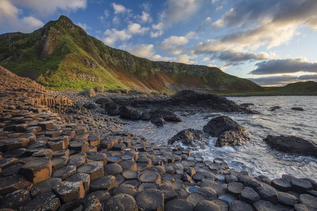 Giant’s Causeway basalt columns with waves crashing against the rugged Antrim coast.