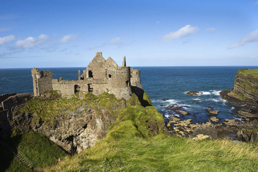 Ruins of Dunluce Castle perched dramatically on cliffs overlooking the Atlantic Ocean in County Antrim.