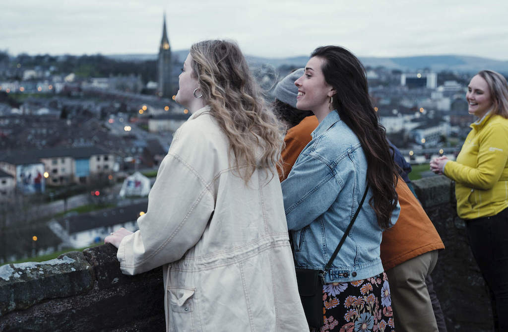 Group of people enjoying the view from the 17th-century city walls of Derry~Londonderry.
