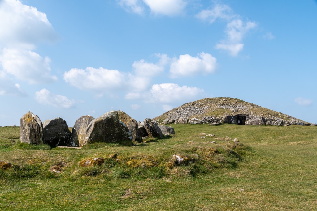 Ancient passage tomb and standing stones of Loughcrew Cairns, County Meath, set against a grassy hillside.