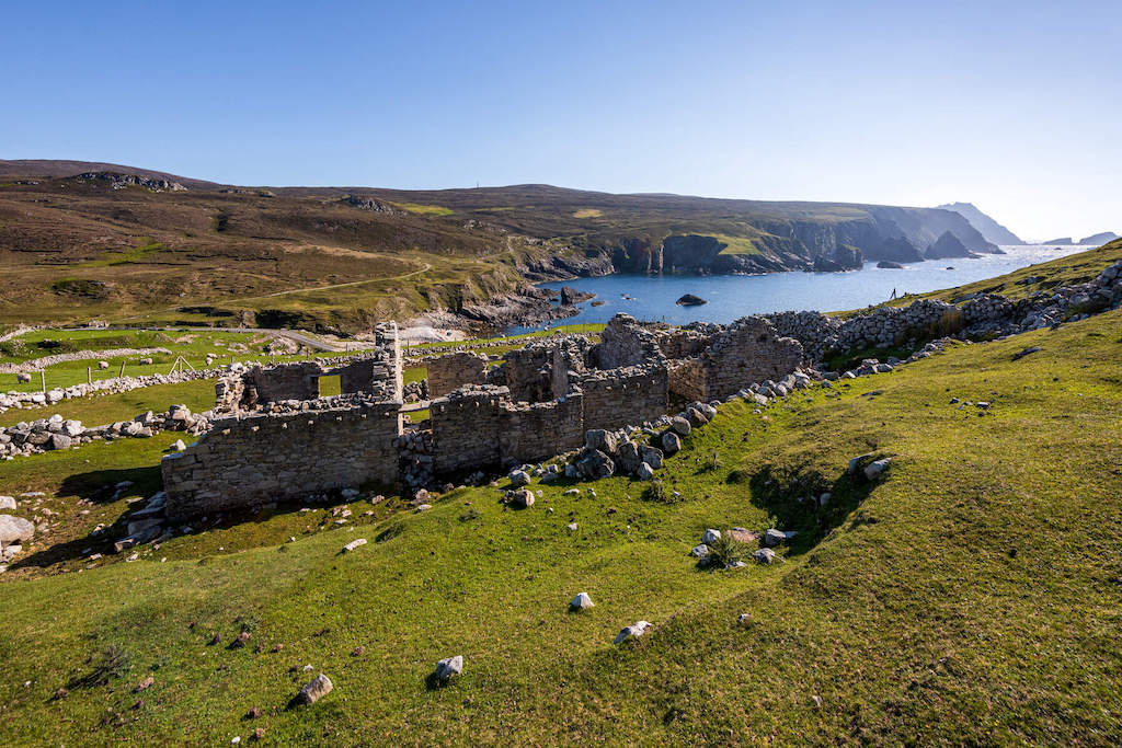 Ruins of an ancient stone settlement overlooking dramatic cliffs and coastline in Glencolmcille, Donegal.