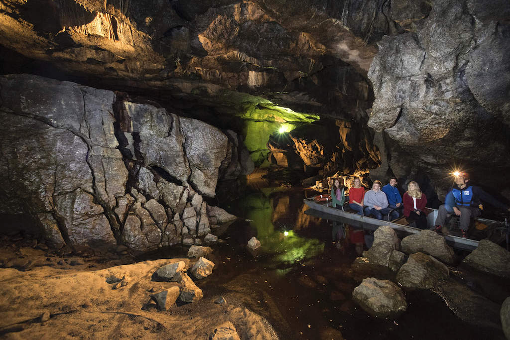Tour group exploring the underground rivers and limestone formations of Marble Arch Caves.