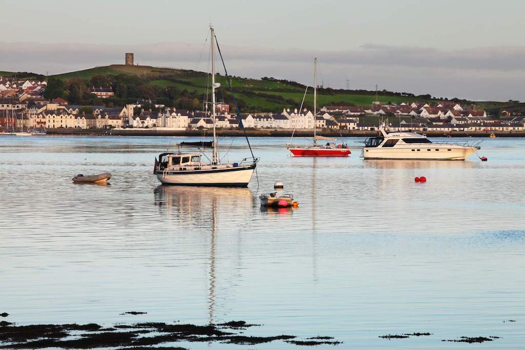 Boats moored in the calm waters of Portaferry Harbour, County Down, with town backdrop.