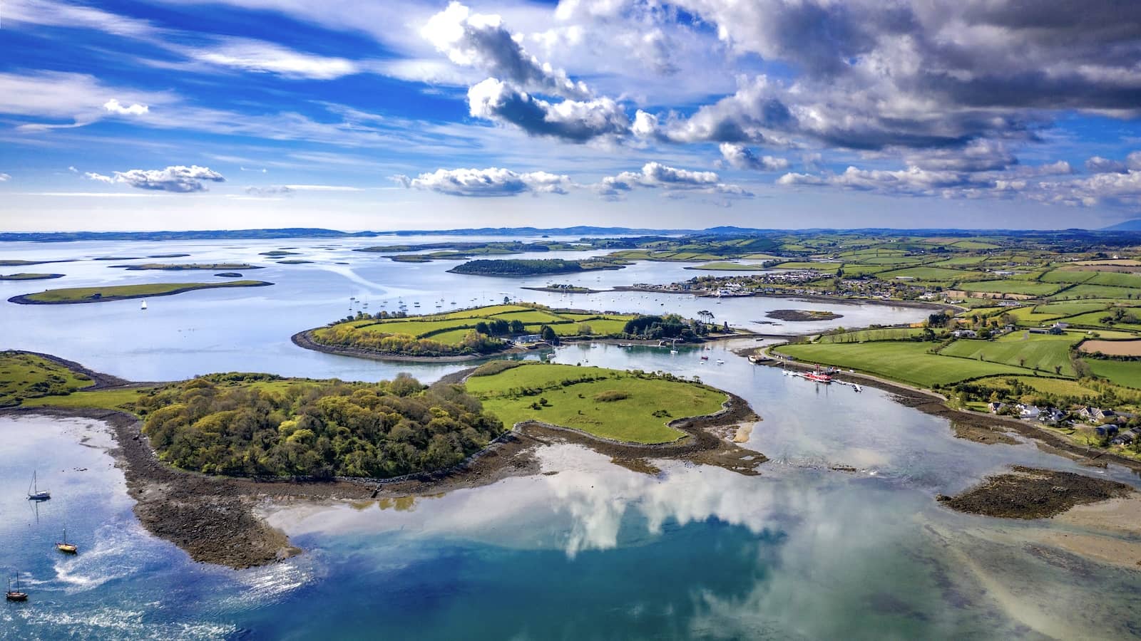 Luchtfoto van Strangford Lough in County Down met kronkelende waterwegen, groene landbouwgrond en dramatische wolken.