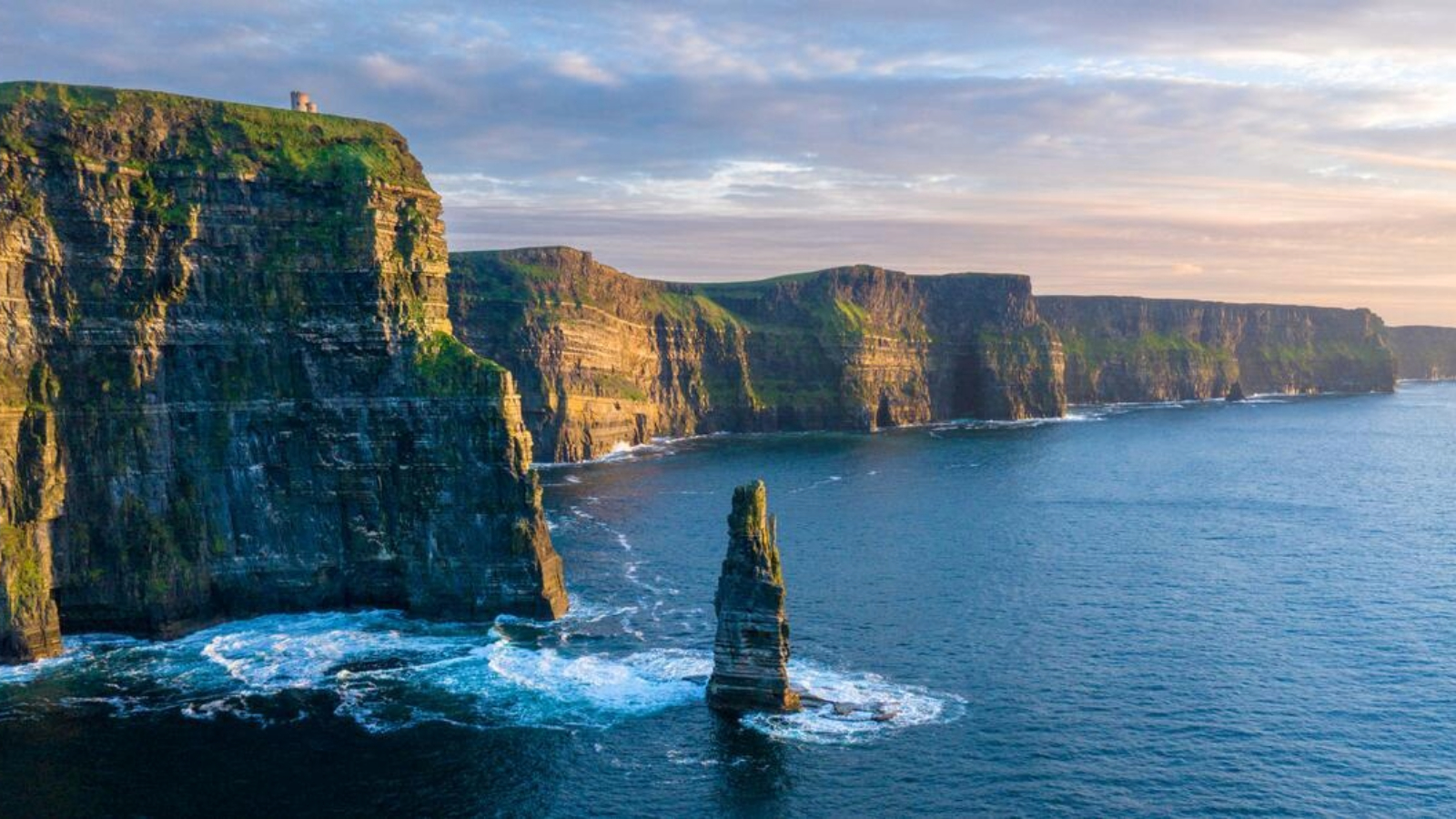 Cliffs of Moher at dusk, County Clare, with Atlantic waves below towering sea cliffs and O'Brien's Tower above.
