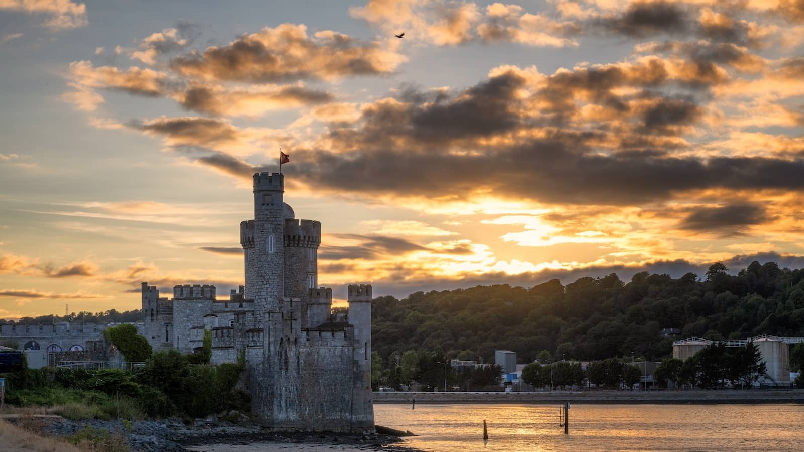 Blackrock Castle on the River Lee, Cork City, at sunset with dramatic sky and waterfront setting.