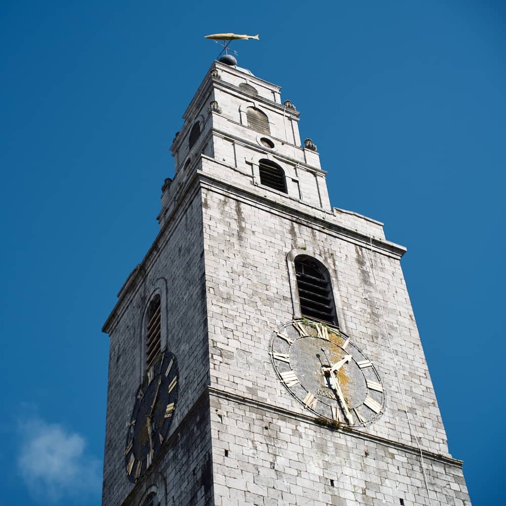 Shandon Bells klokkentoren in Cork, een historisch herkenningspunt met een windvaan in de vorm van een vis tegen een strakblauwe hemel.