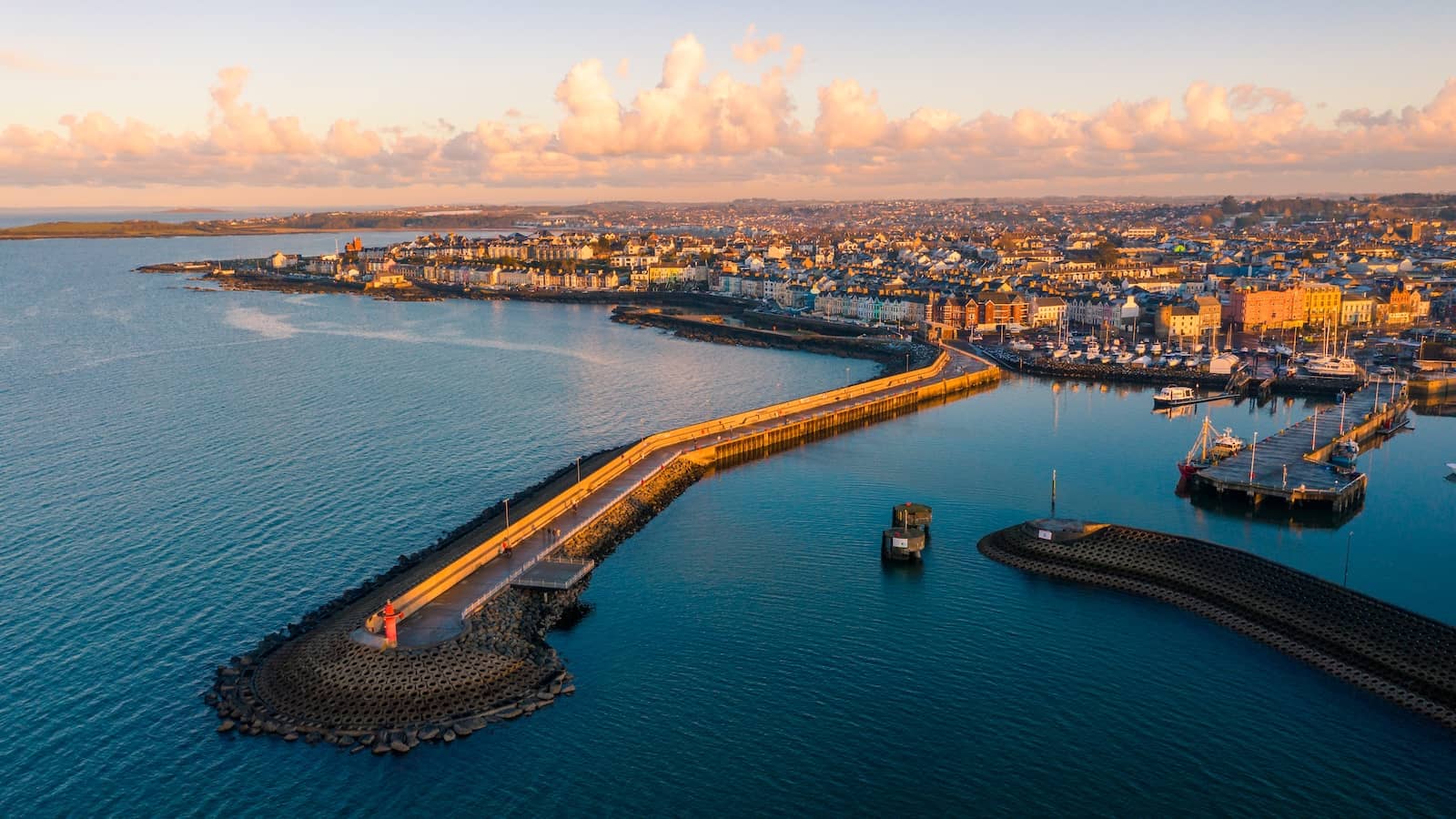 Luchtfoto van de haven van Bangor in County Down met jachthaven, promenade langs de zee en kalme kustwateren bij zonsondergang.