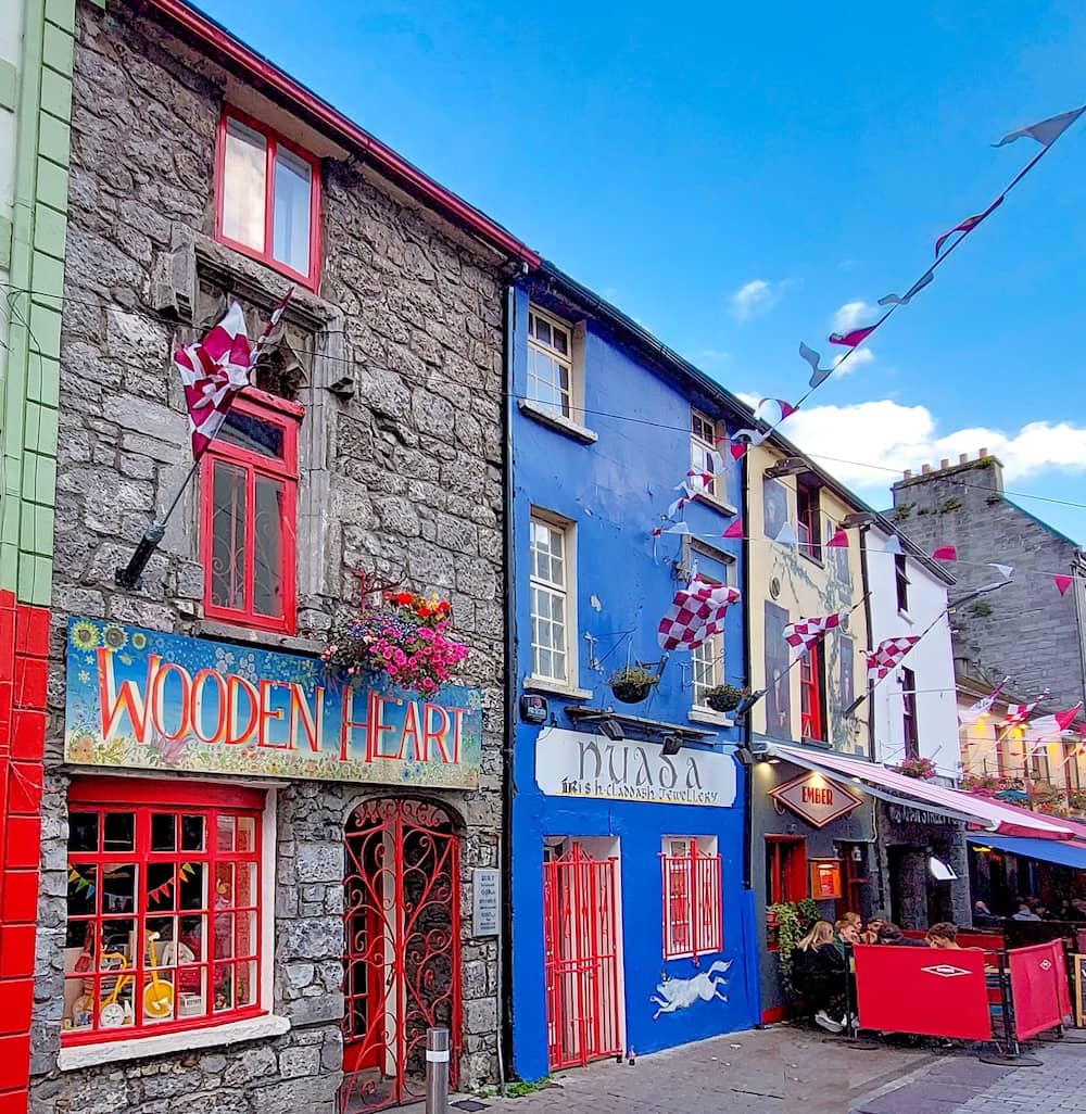 Devantures colorées de Quay Street, à Galway, avec guirlandes de fanions, cafés et bâtiments traditionnels en pierre.