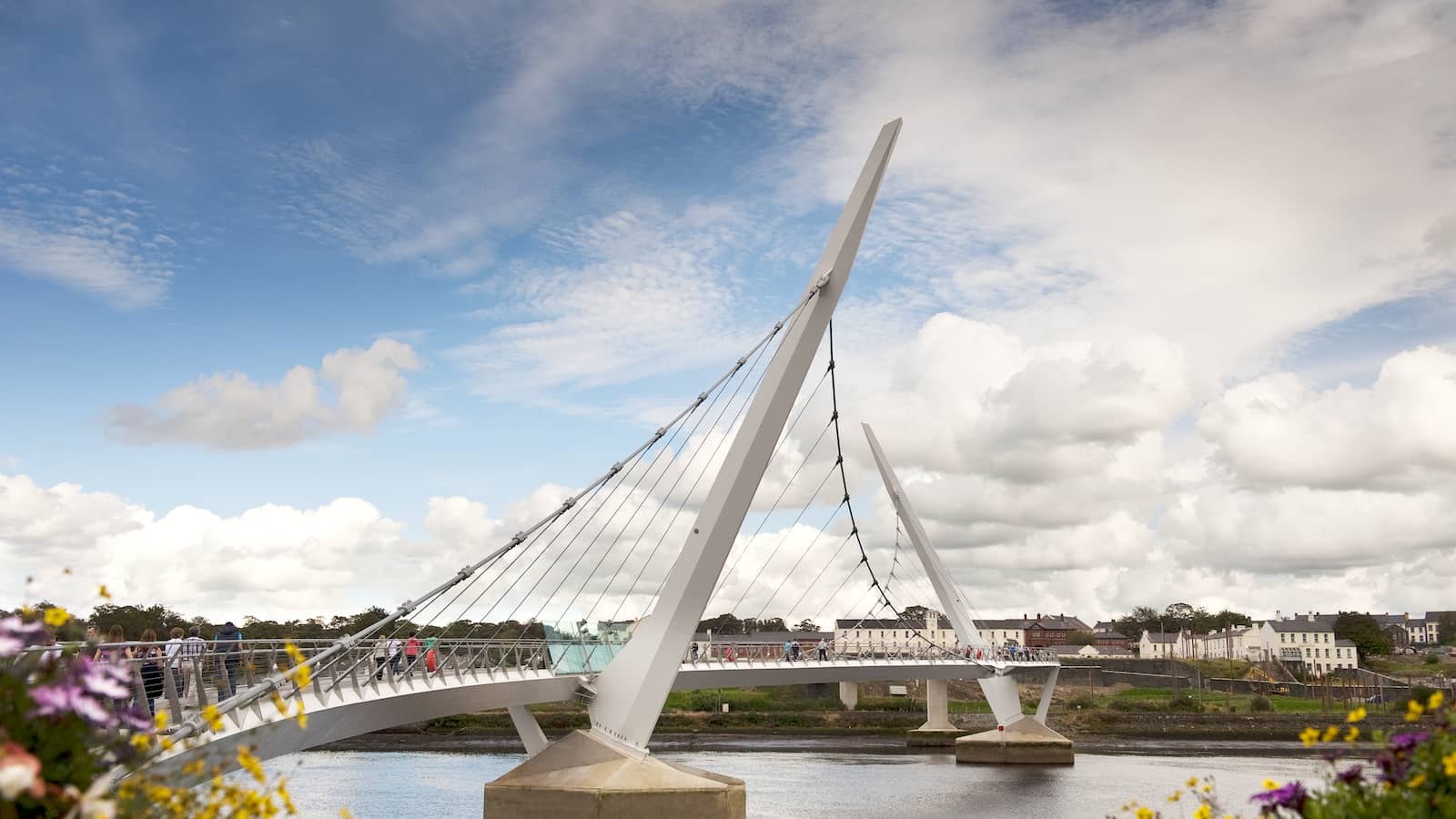 People crossing the Peace Bridge over the River Foyle in Derry city.
