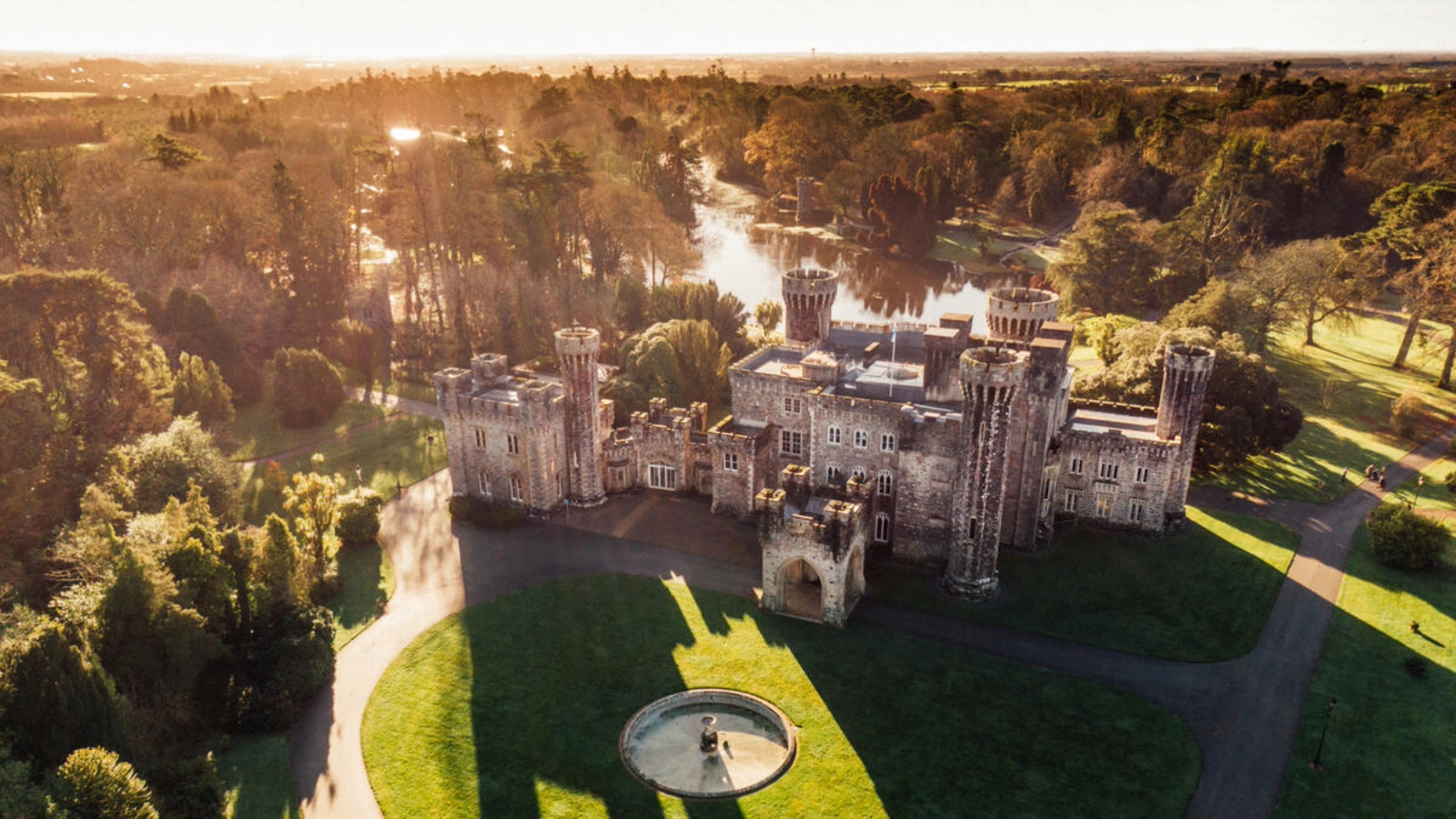 Aerial view of Johnstown Castle in County Wexford surrounded by woodland, lakes and landscaped gardens.