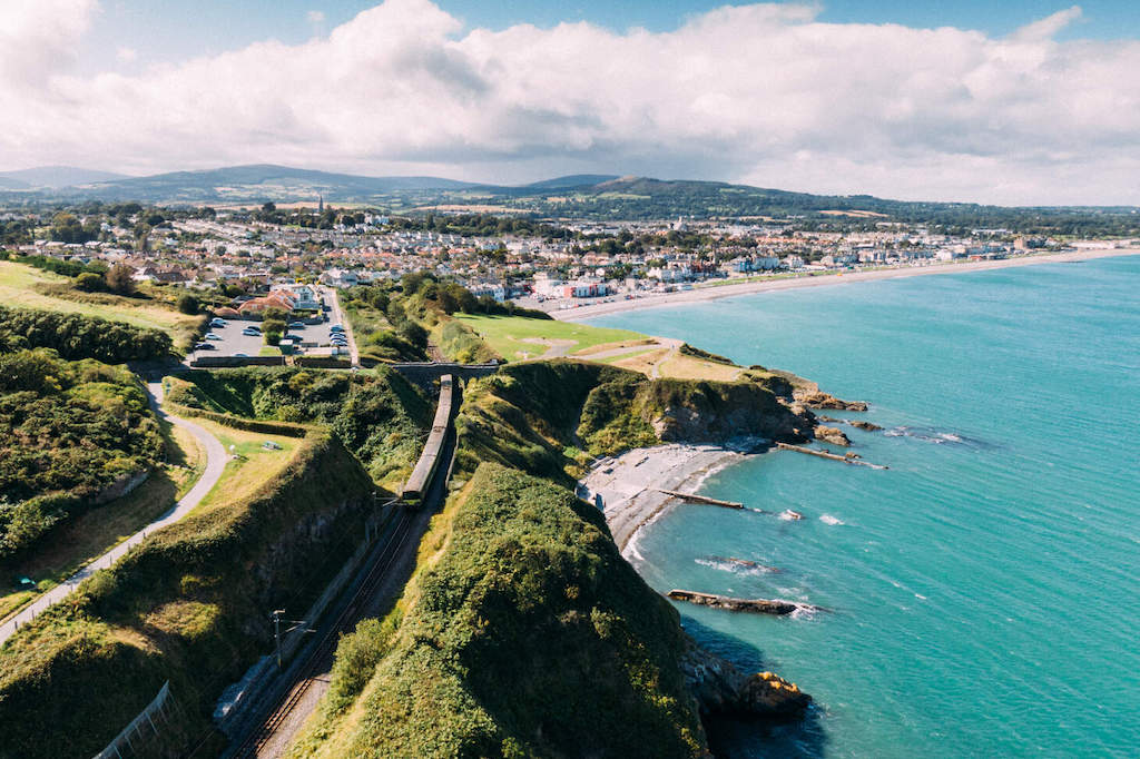 Aerial view over Bray seafront, sandy beach, town centre and DART line running along the Wicklow coastline.