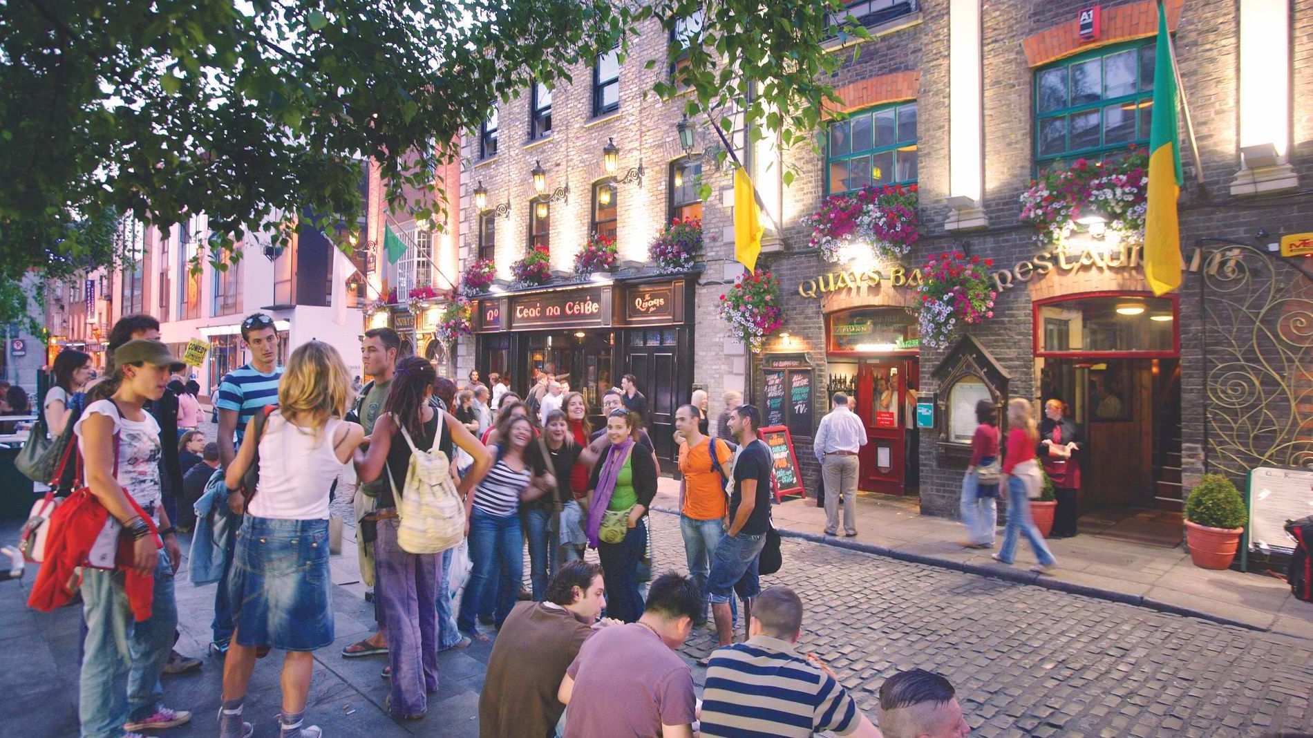 Een levendige menigte buiten pubs op geplaveide straten in de wijk Temple Bar van Dublin.