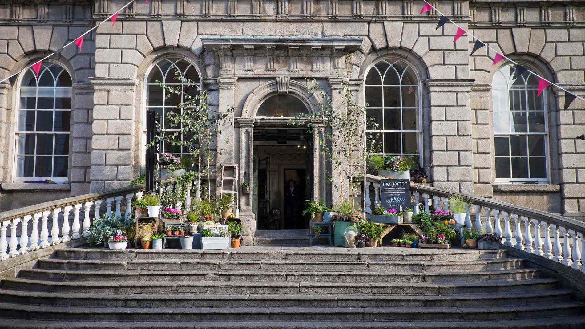 De ingang van het georgiaanse Powerscourt Centre in Dublin, versierd met planten en bloemen.