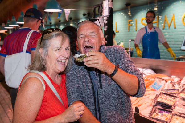 A couple smiling while eating oysters