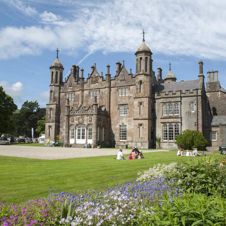 Tourists exploring the gardens and historic Gothic architecture of Glenarm Castle in County Antrim.