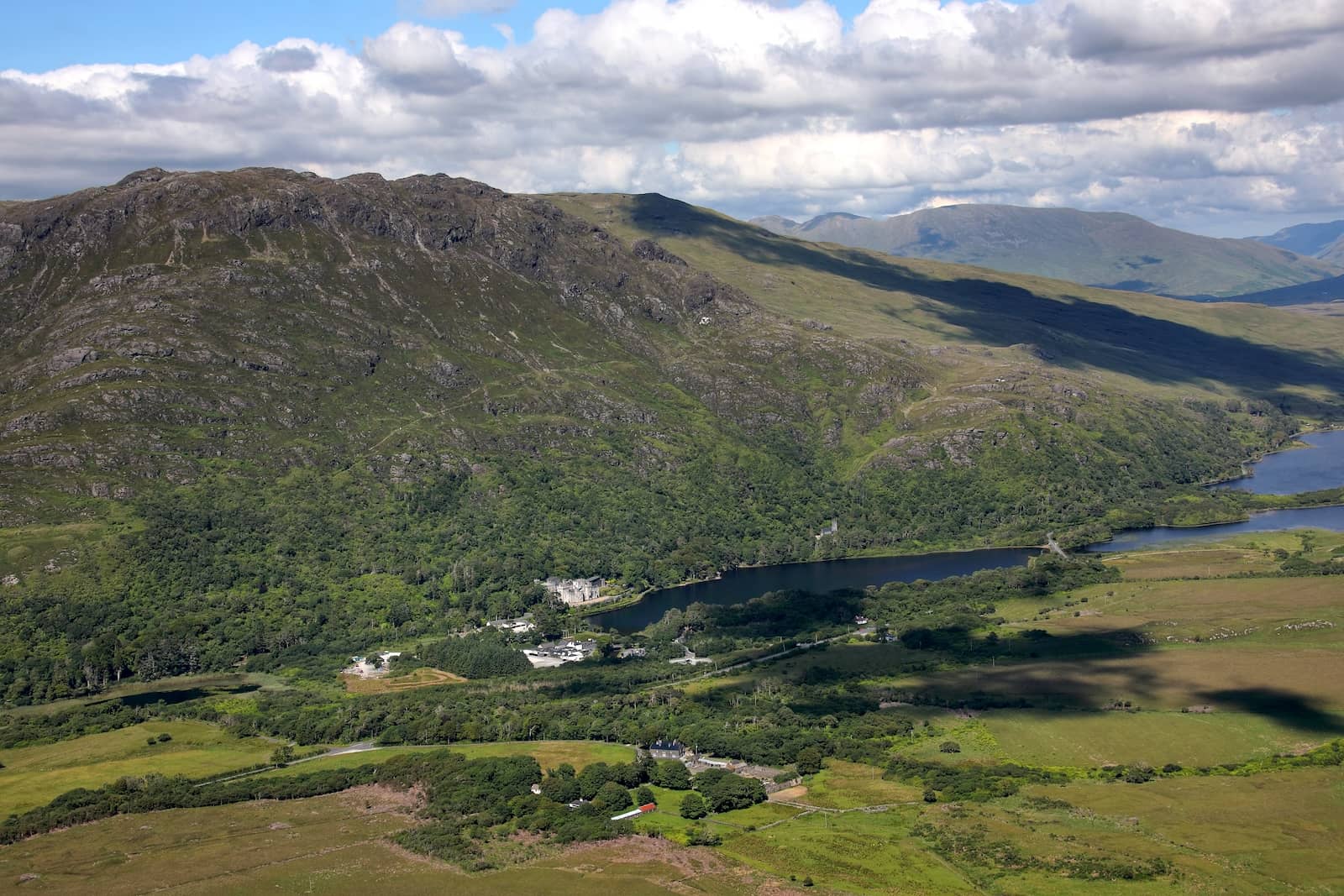 Aerial view of Kylemore Abbey nestled by a lake amid the Connemara mountains in County Galway.