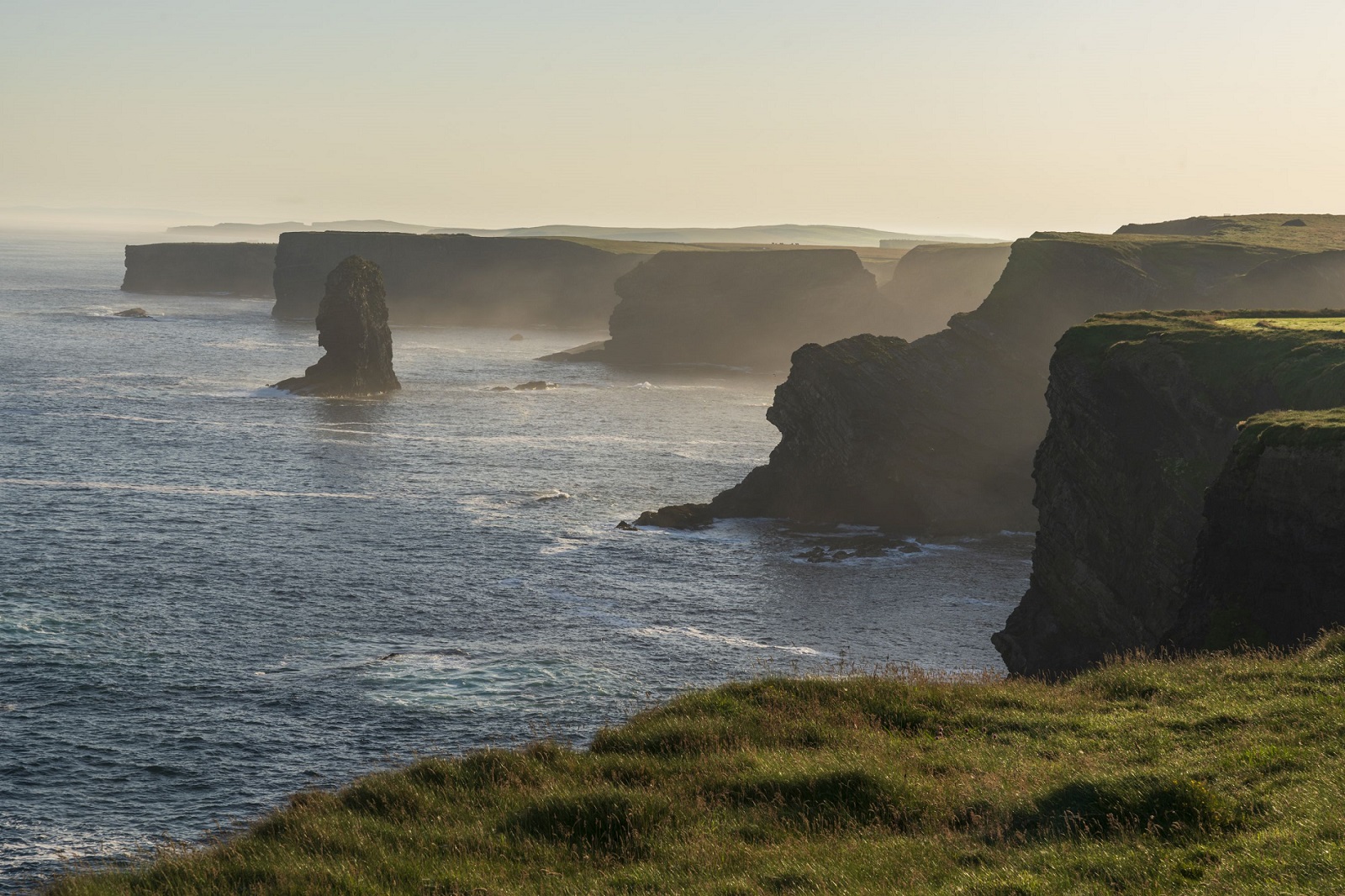 Irische Klippenlandschaft mit steilen Felsen und Atlantikbrandung im Abendlicht