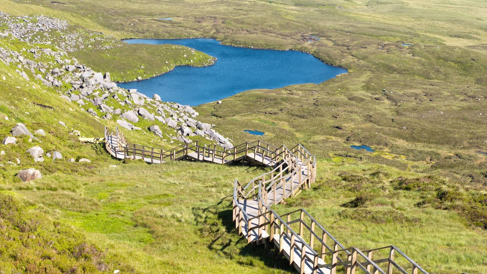 Wooden boardwalk winds across blanket bog on Cuilcagh Mountain overlooking upland lakes, County Fermanagh.