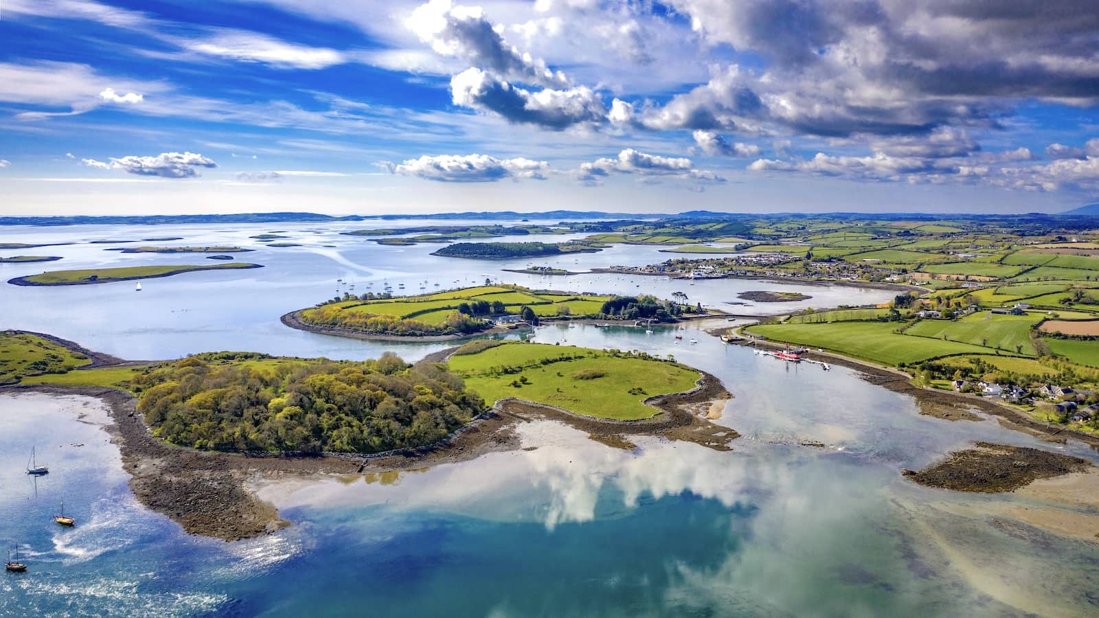 Aerial view of Strangford Lough’s islands, inlets and patchwork fields under a bright sky, County Down.