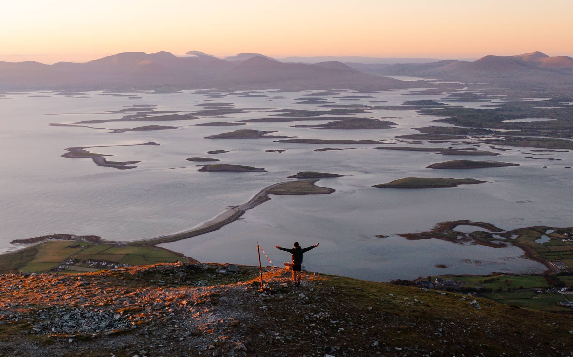 Sunset over Clew Bay in County Mayo, with scattered islands stretching across calm coastal waters.