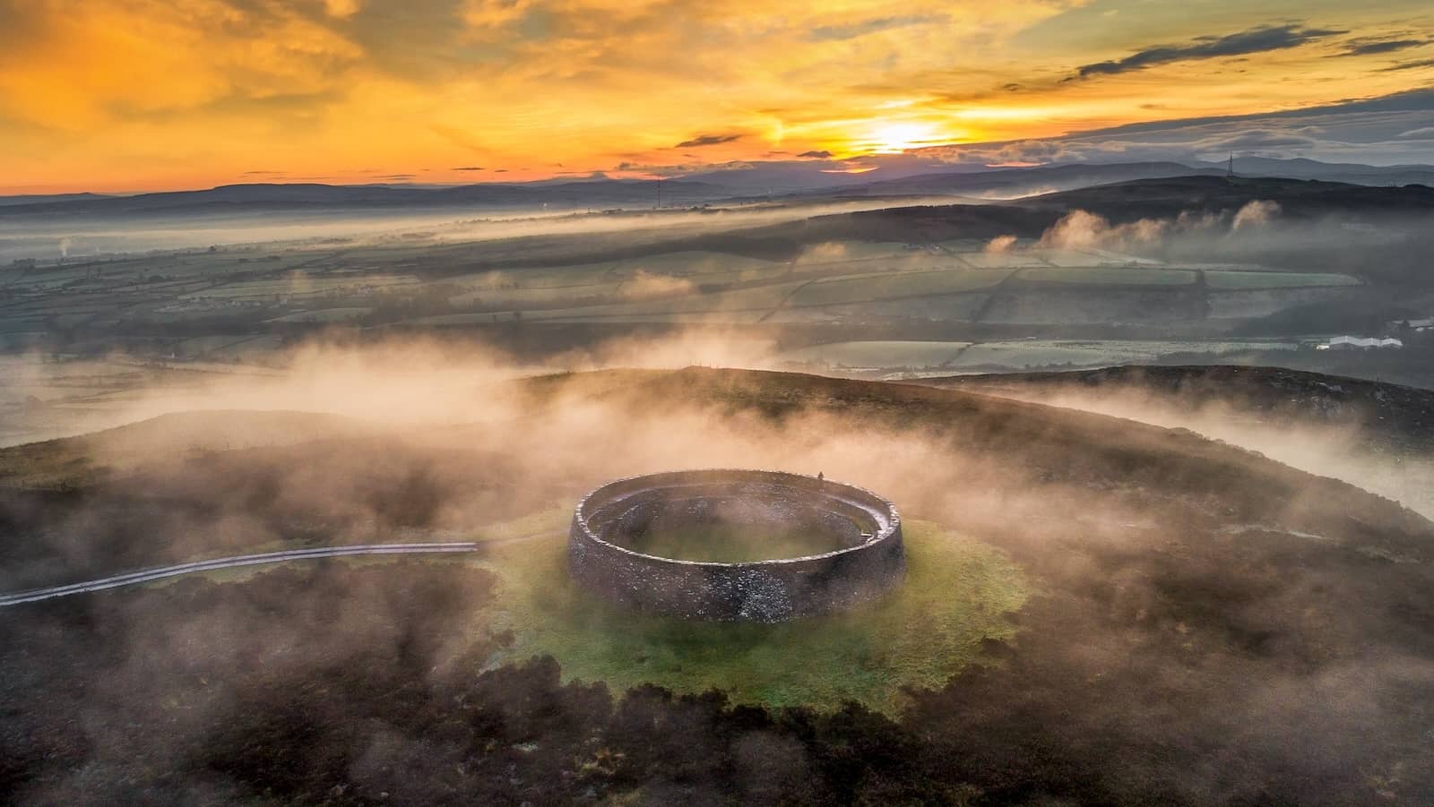 Aerial view of Grianan of Aileach stone ringfort surrounded by mist at sunrise, County Donegal.