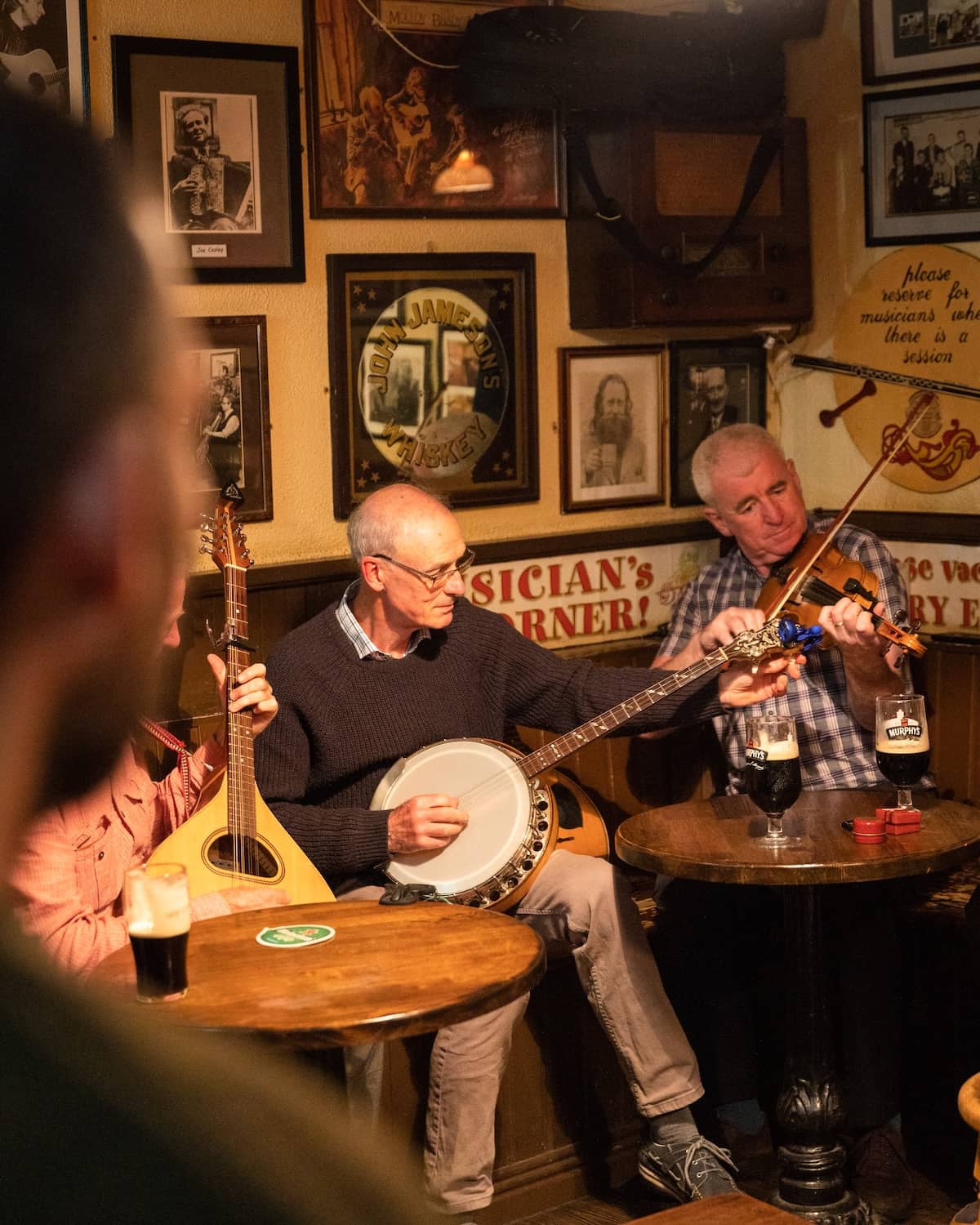 Traditional Irish music session with musicians playing fiddle and banjo in Matt Molloy's pub, Westport, County Mayo.