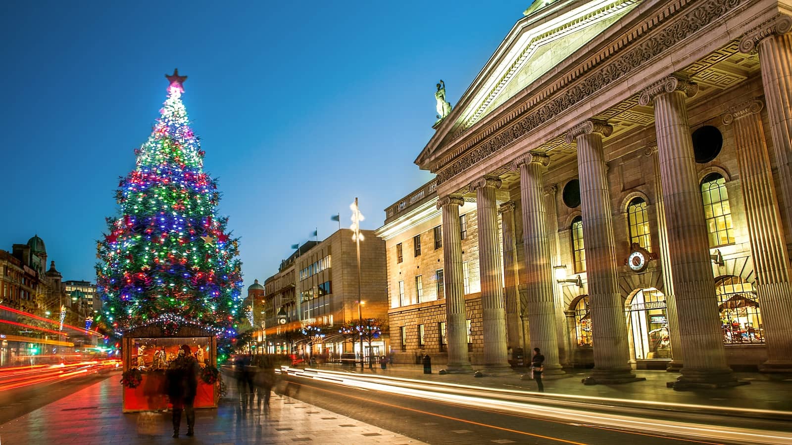 Kerstboomverlichting op O'Connell Street naast het GPO, Dublin, die 's avonds in de drukte van de stad oplicht.