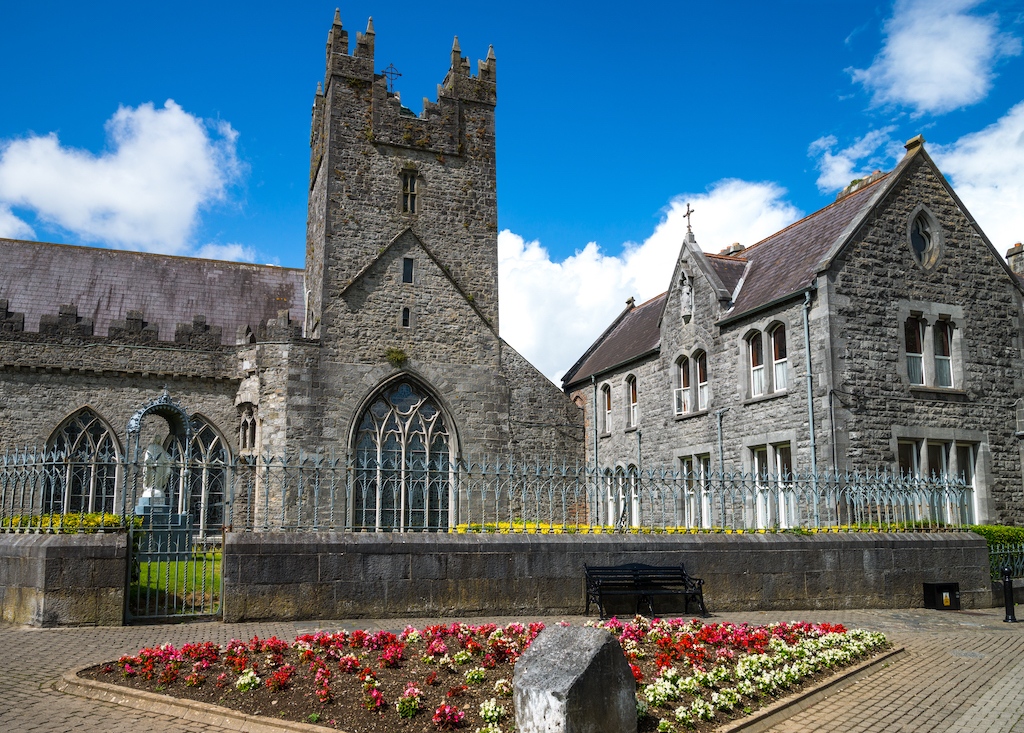 De Black Abbey in Kilkenny, een middeleeuwse stenen kerk met een toren, gotische ramen en tuinen.
