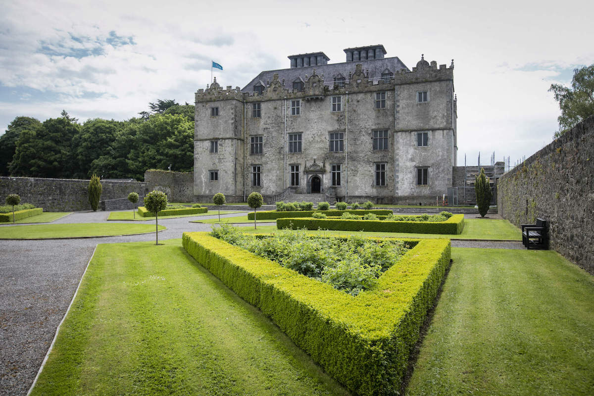 Formale, von Hecken eingefasste Gärten, die zur prächtigen Fassade des Portumna Castle, Grafschaft Galway, führen.