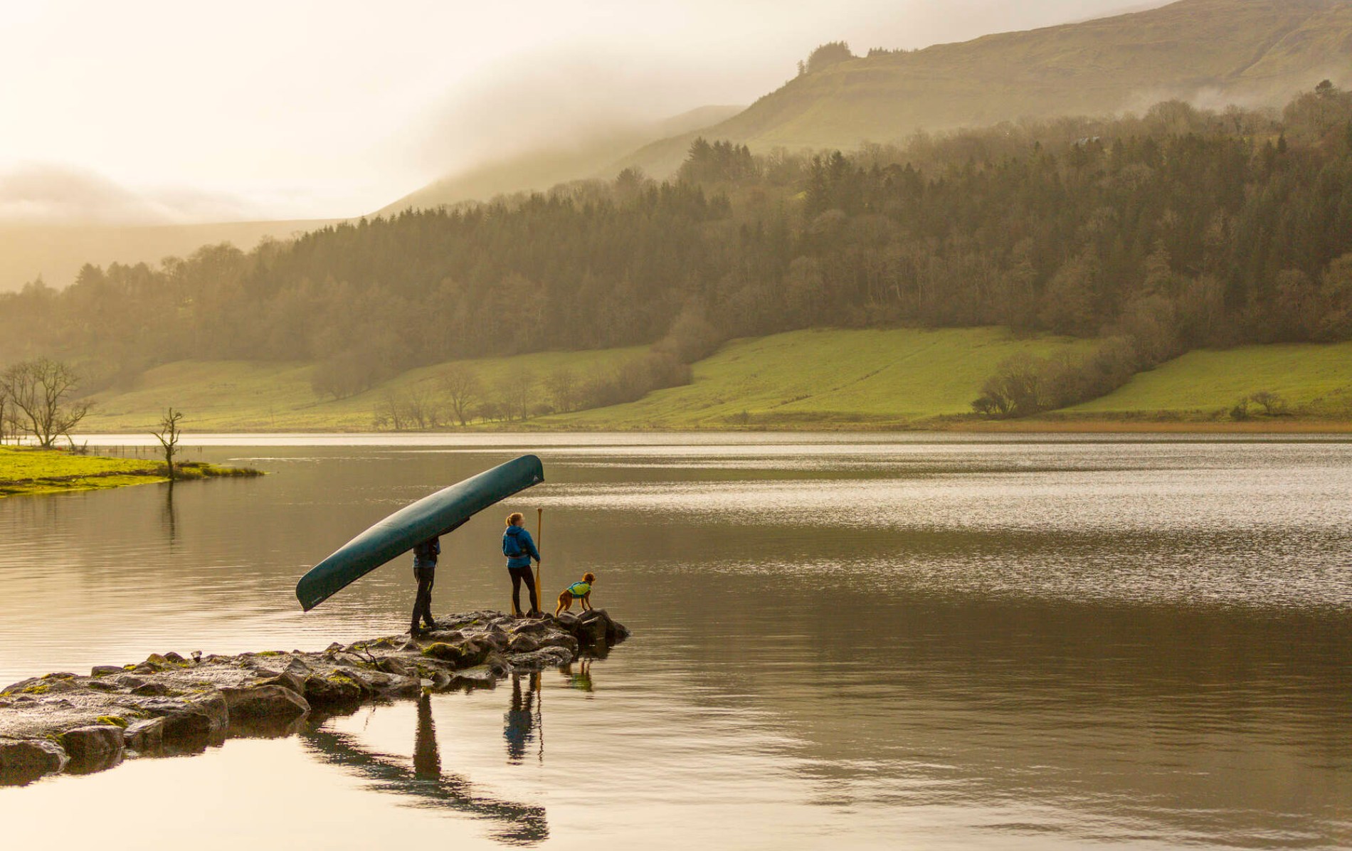 Mensen dragen een kano langs de rotsachtige oever van het Glencar-meer in county Leitrim.