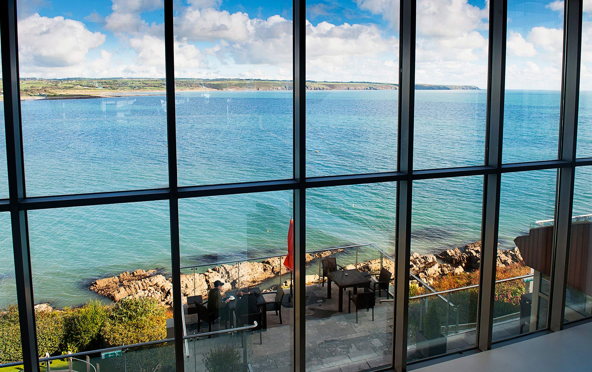Coastal dining view through glass windows at Cliff House Hotel, County Waterford.